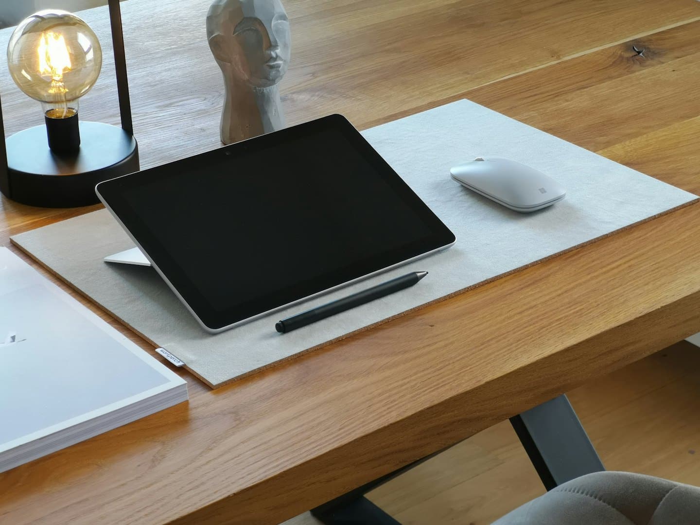 Tablet, rysik i myszka na drewnianym biurku.