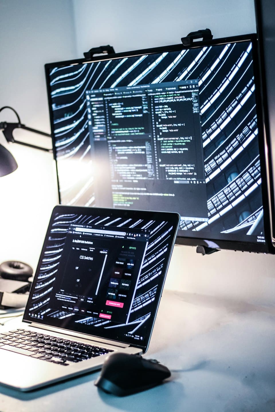 Laptop i monitor wyświetlające kod w nowoczesnym biurze.